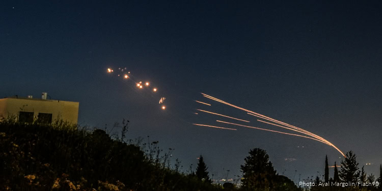 Multiple missiles or projectiles launched into the night sky with visible trails and explosions, possibly indicating a military or conflict-related event.
