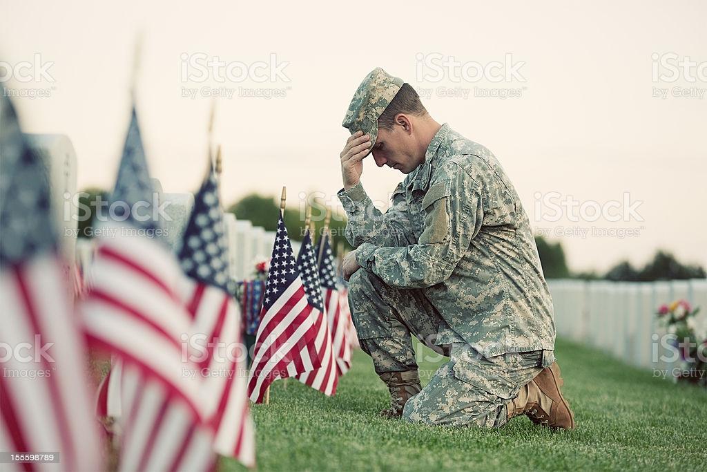 soldier-kneeling-at-grave-picture-id155598789