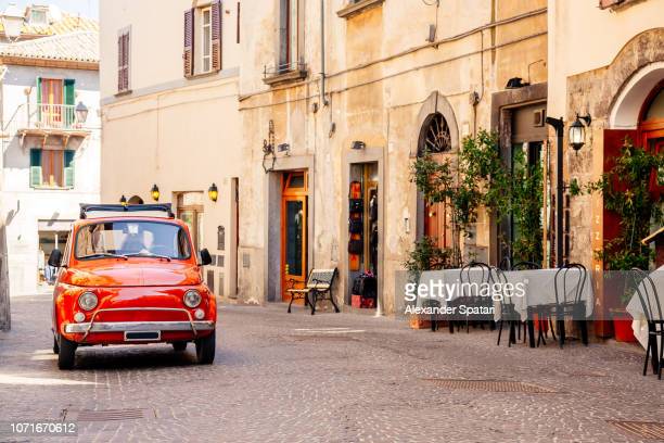 old-red-small-vintage-car-on-the-street-of-italian-city-on-a-sunny-picture-id1071670612