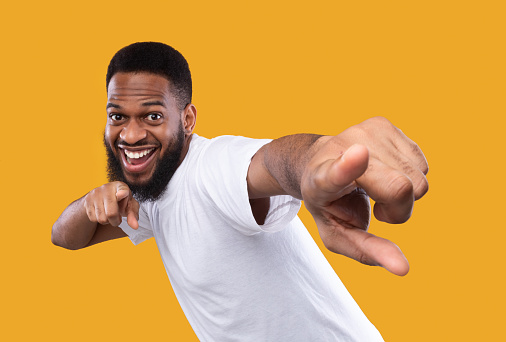 funny-african-man-posing-pointing-fingers-at-camera-yellow-background-picture-id1298255522