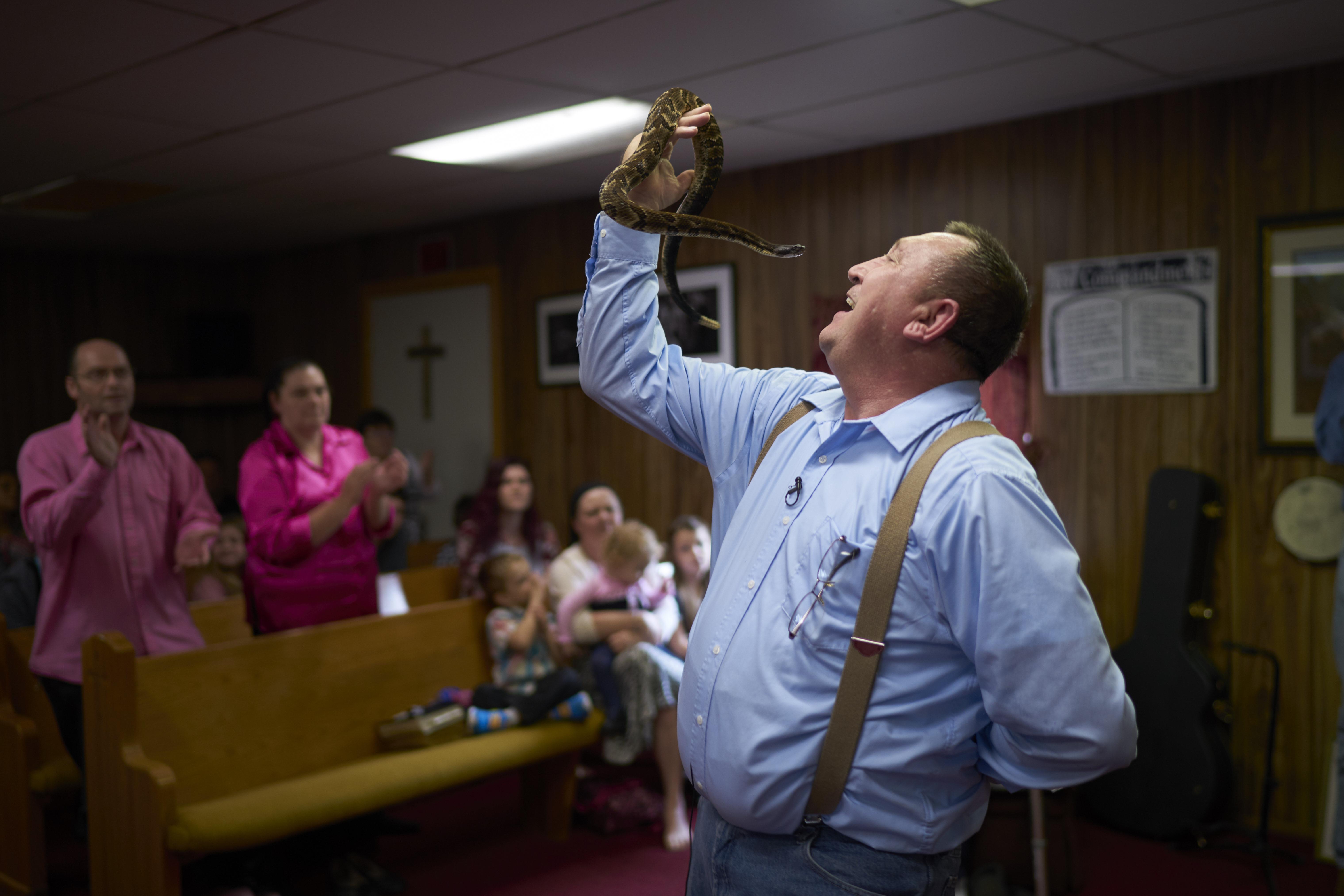  Pastor Chris Wolford holds a poisonous rattlesnake just inches from his face