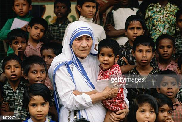 mother-teresa-accompanied-by-children-at-her-mission-in-calcutta-picture-id56799974