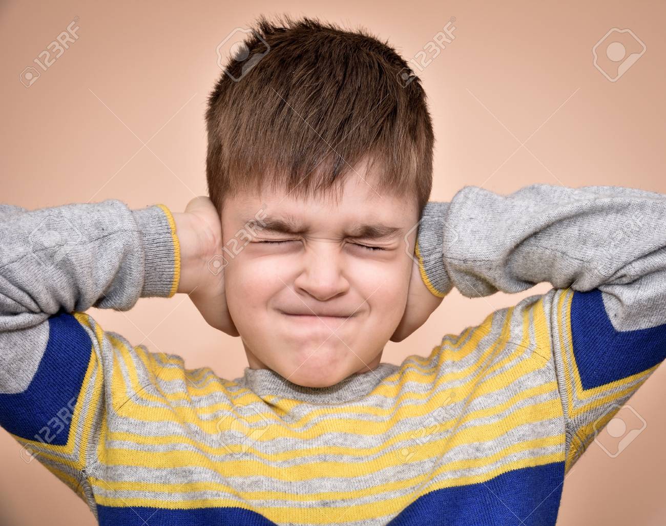 70491323-young-boy-with-closed-eyes-covering-ears-with-hands.jpg